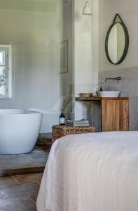 a white bedroom with a tub and a sink at Boutique hotel Mezi plutky in Čeladná