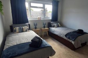 um quarto com 2 camas e uma janela em ZARA APARTMENTS PT 3 em Dundee