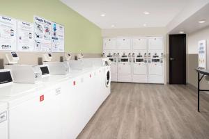 a laundry room with white washing machines and cabinets at WoodSpring Suites Chicago Tinley Park in Tinley Park