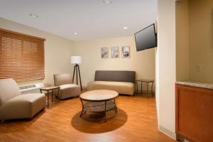 a living room with a couch and a table at WoodSpring Suites Chicago Romeoville in Romeoville