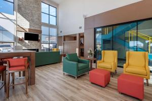 Comfort Suites Colorado Springs East - Medical Center Area في كولورادو سبرينغز: لوبى مع كراسي ملونة وطاولة
