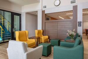 a waiting room with yellow and green chairs at Comfort Suites Colorado Springs East - Medical Center Area in Colorado Springs