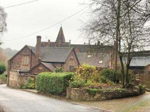 an old brick house with a church in the background at Jackfield Old School in Coalport