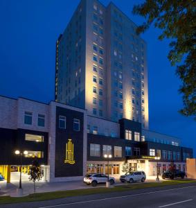 a tall building with cars parked in front of it at Halifax Tower Hotel & Conference Centre, Ascend Hotel Collection in Halifax