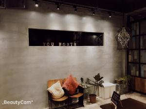 um quarto com uma cadeira e uma placa na parede em You Worth Inn em Hualien City