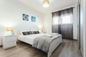 a white bedroom with a bed and a window at Best Houses 05 - The Best Location in Ferrel