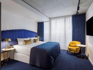 a hotel room with a bed and a yellow chair at The Jazz Corner Hotel Melbourne in Melbourne