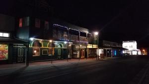 een lege straat 's nachts met gebouwen met verlichting bij Hunters Hotel in Queenstown