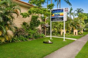 a sign in front of a house with aosis inn at Oasis Inn Apartments in Cairns