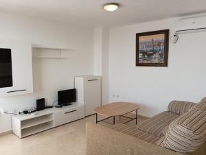 salon z kanapą i stołem w obiekcie Torres Montecarlo Apartmento con vistas al mar w mieście Benidorm