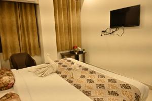 a bedroom with a bed and a tv on the wall at Hotel Shine Star By Tag Your Trip Near Golden Temple in Amritsar