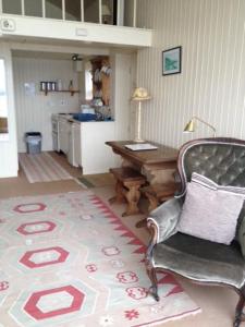 a living room with a desk and a chair and a rug at The Baby House @ Wood Quay, Carlingford in Carlingford