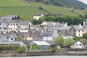 a group of houses in a town next to the water at The Baby House @ Wood Quay, Carlingford in Carlingford