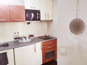 a kitchen with white cabinets and a black counter top at Nice & economic Studio in Baia Mare