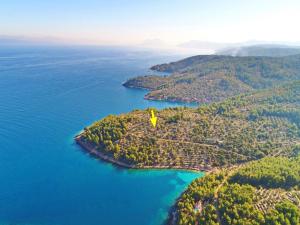 an island in the water with a yellow flag on it at Green Area Stone House in Vela Luka