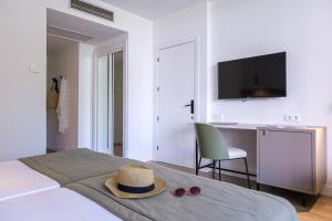 a bedroom with a bed with a hat and a desk at Estival Islantilla in Islantilla