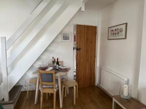 a dining room with a table and a wooden door at Explorers Cottage, Yorkshire Wolds Character Home in Market Weighton