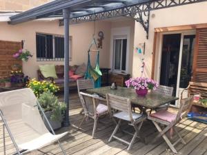un patio avec une table et des chaises sur une terrasse dans l'établissement CALME , PROCHE du Centre, Grande Terrasse, Petit déjeuner, à Bordeaux