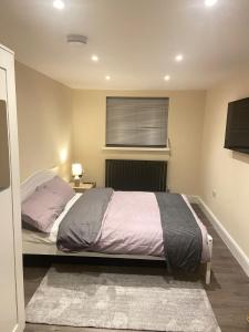 um quarto com uma cama grande e uma janela em BEAUTIFUL ROOMS ONLY FEW STEPS AWAY FROM BRUCE GROVE TOTTENHAM STADIUM em Londres