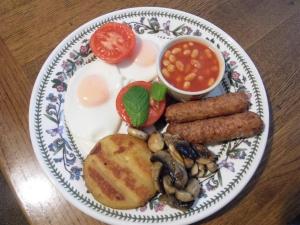een bord ontbijtproducten met eieren, worst en bonen bij Clerk Laithe Lodge in Newton