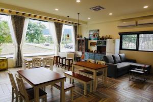 a living room with a couch and tables and a kitchen at Country Road B&B in Guangfu