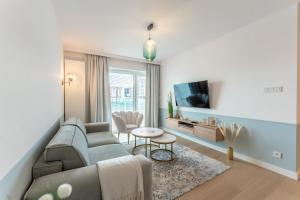 salon z kanapą i telewizorem w obiekcie Aqua Polanki Apartament B014 Eltom Tour w Kołobrzegu