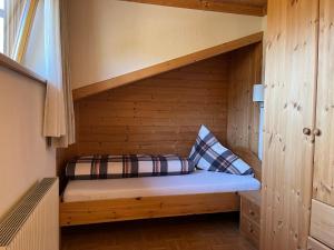 ein Schlafzimmer mit einem Bett in einer Holzhütte in der Unterkunft Bergmanns Ferienapartment in Debant