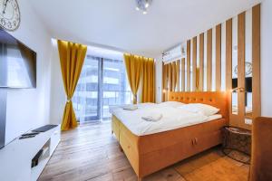 a bedroom with a bed and a large window at Mayad Residence in Warsaw