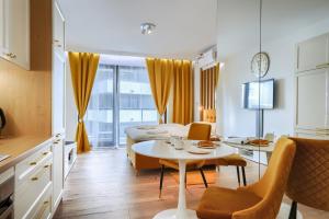 Mayad Residence في وارسو: مطبخ وغرفة معيشة مع طاولة وكراسي