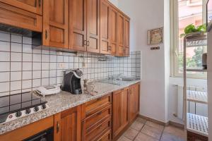 a kitchen with wooden cabinets and a sink at Quirinale View 52 in Rome