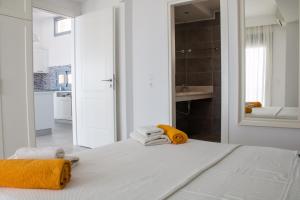 um quarto branco com uma cama com toalhas em Blue Horizon 2 em Lindos