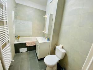 a bathroom with a toilet and a sink and a tub at Plaza Residence Studio 2 in Bucharest