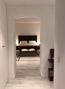 a bedroom with a bed in a white room at Preciosos apartamento cerca de Atocha CAN in Madrid