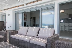 a couch sitting on a screened in porch at Blue Horizon 2 in Líndos
