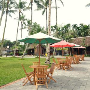 a group of tables and chairs with umbrellas at Kayon Griya Osing Villa - Ijen in Licin