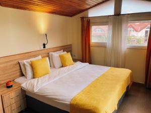 een slaapkamer met een bed met gele kussens en een raam bij Ten Apart Hotel in Fethiye