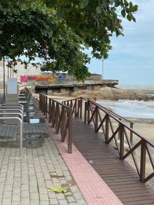 a wooden boardwalk next to the beach with a pier at Suites do Mar in Marataizes