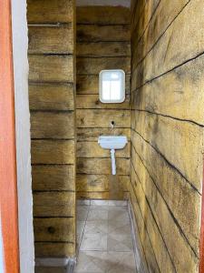 a bathroom with a sink in a wooden wall at Suites do Mar in Marataizes