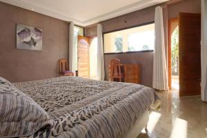 a bedroom with a large bed and a large window at Villa Pepe in El Harkat