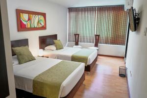 a hotel room with two beds and a window at Hotel Volare in Armenia