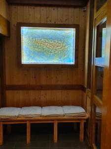 um banco num quarto com uma pintura na parede em Gîte Beau Soleil em Cauterets