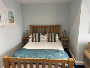 a bedroom with a bed with a wooden headboard and pillows at Sawyers Bed and Breakfast in Looe