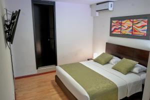 a bedroom with a bed and a painting on the wall at Hotel Volare in Armenia