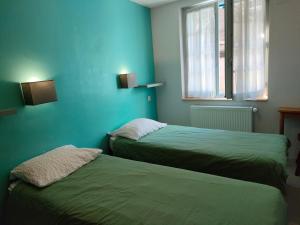 two beds in a room with blue walls at Gîte Beau Soleil in Cauterets