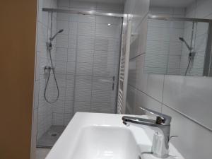 a white bathroom with a sink and a shower at Gîte Beau Soleil in Cauterets