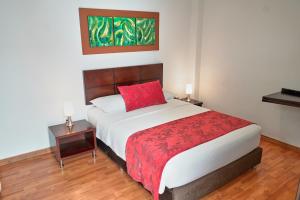 a bedroom with a large bed with a red pillow at Hotel Volare in Armenia