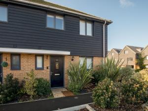 a black house with a black door and some bushes at Pass the Keys Stylish 2BR House in Leafy Warfield with Garden in Bracknell