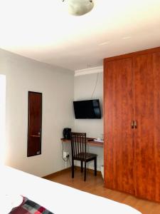 a bedroom with a desk and a chair and a television at Blue Crane Guesthouse in Maseru