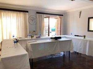 a dining room with two tables with white table cloth at Blue Crane Guesthouse in Maseru
