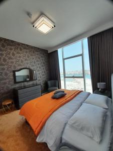 a bedroom with a large bed and a large window at LUXURY 2 Bedroom Apartment in GATEWAY Residence in Ras al Khaimah